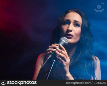 Beautiful woman sings, smoky stage on background