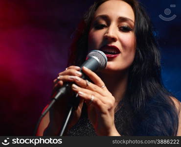 Beautiful woman sings, smoky stage on background