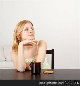 beautiful woman sitting at table drinking tea