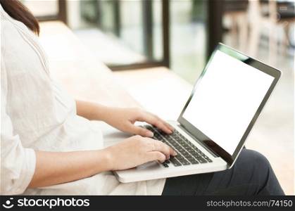 Beautiful woman sitting at the stair and working on a laptop with blank screen