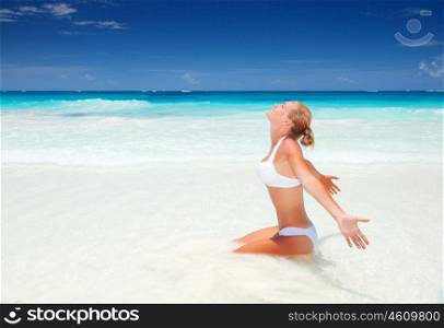 Beautiful woman sitting down on clean white sandy beach, enjoying sunny day, luxury tropical resort, summer vacation concept&#xA;