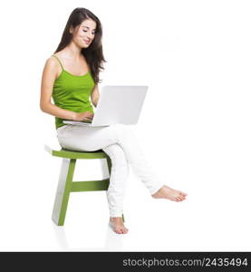 Beautiful woman sitting in a chair working with a laptop, isolated over a white