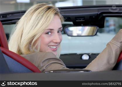 Beautiful woman sitting in brand new car