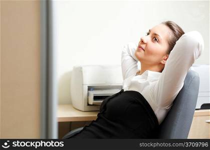 Beautiful woman sitting in the chair and relaxing at office