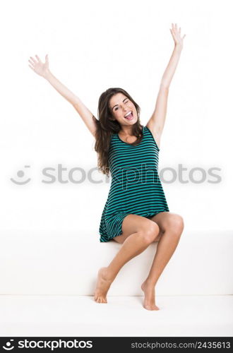 Beautiful woman sitting in the couch, isolated over a white background