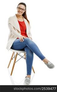Beautiful woman sitting on a chair and smiling, isolated over white background