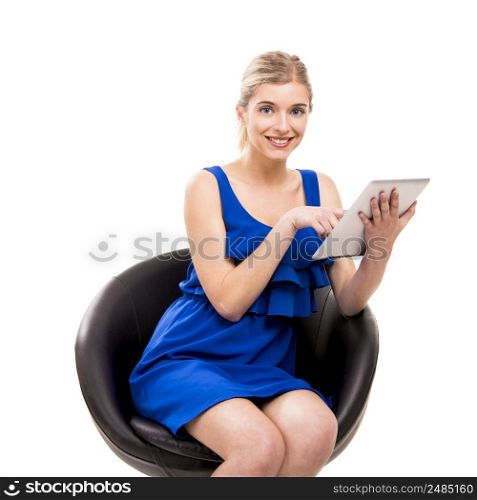 Beautiful woman sitting on a chair working with a tablet, isolated over white background