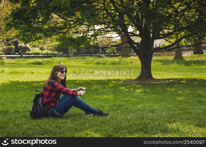 Beautiful woman sitting on rhe grass and relaxing
