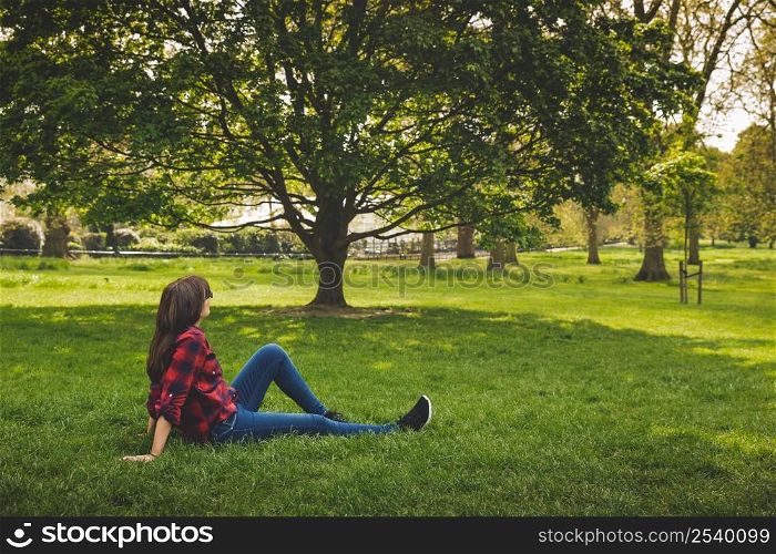 Beautiful woman sitting on rhe grass and relaxing
