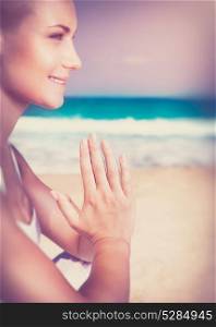 Beautiful woman sitting on the beach and meditating, harmony of soul, happy healthy life