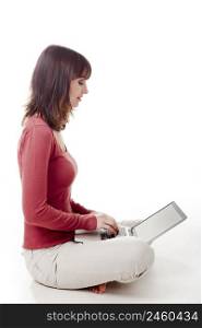Beautiful woman sitting on the floor and working with a laptop