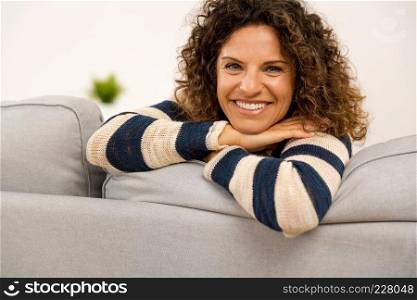 Beautiful woman sitting on the sofa  and smiling