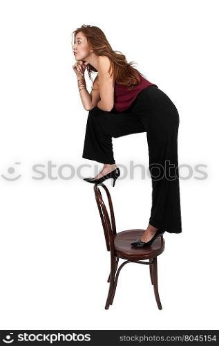 Beautiful woman standing on a antique chair