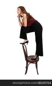 Beautiful woman standing on a antique chair