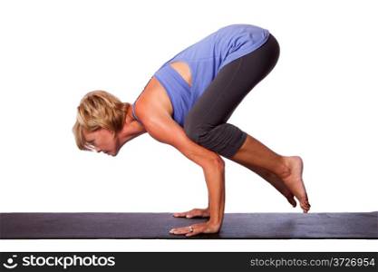 Beautiful woman standing on hands with feet lifted up doing Crane Bakasana yoga pose, on white.