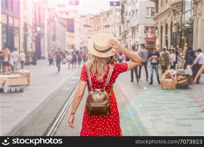 Beautiful woman stands at Istiklal street,a popular location in Beyoglu district,Istanbul,Turkey. Beautiful woman in red dress stands at Istiklal street