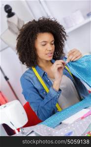 beautiful woman stitching fabric using a sewing machine