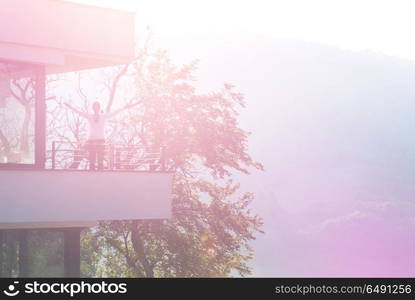 Beautiful woman stretching her arms and enjoying early morning on balcony. woman stretching her arms on balcony