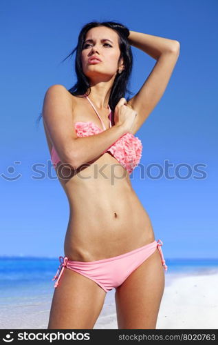 beautiful woman sunbathing in pink bathing suit on beach