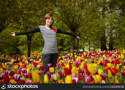 Beautiful woman surrounded by tulips of all the colors