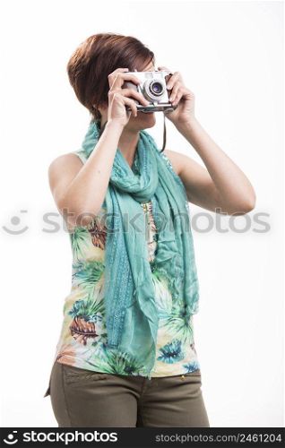 Beautiful woman taking a photo with a vintage camera, isolated over white background