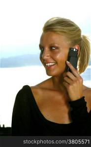 Beautiful woman talking on cell phone while looking at copyspace