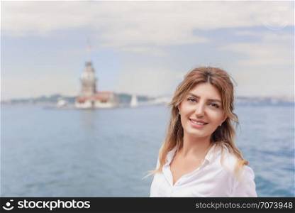 Beautiful woman traveler is in front of Maiden Tower,a popular destination in Istanbul,Turkey. Beautiful woman traveler is in front of Maiden Tower,a popular destination in Istanbul,Turkey