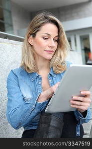 Beautiful woman using electronic tab in the street