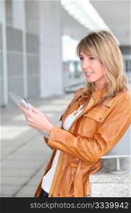 Beautiful woman using electronic tablet in town