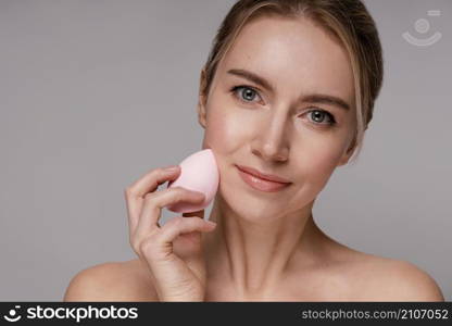 beautiful woman using make up blender