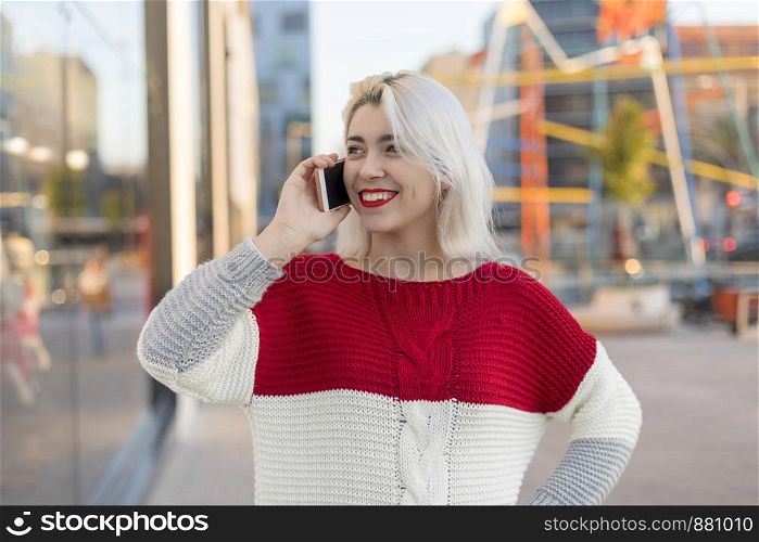 Beautiful woman using mobile in the street.