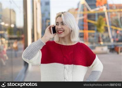 Beautiful woman using mobile in the street.