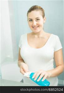 Beautiful woman using moisturizing lotion at bathroom in morning