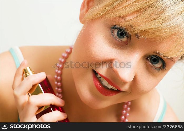 Beautiful woman using perfume and enjoying it visibly