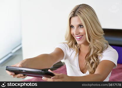 Beautiful woman using Tablet PC as remote control