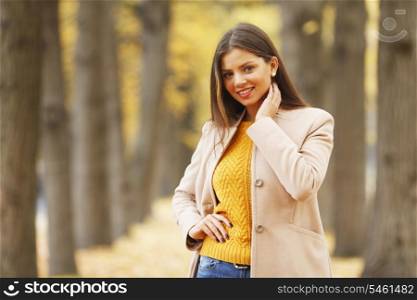 Beautiful woman walking at alley in autumn park