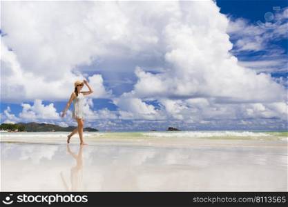 Beautiful woman walking in the beautiful beach of Praslin, Seychelles