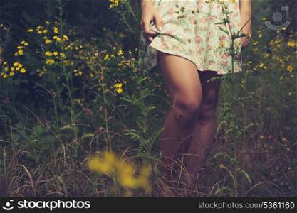 Beautiful woman walks at the country barefoot. Mid part of the body
