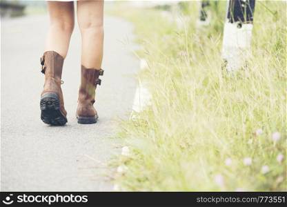 Beautiful Woman Wear Brown Boots Walking on the road.