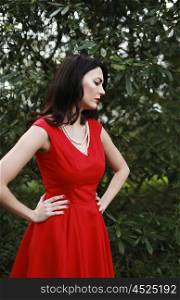 Beautiful woman wearing a red dress standing with hands on her hips