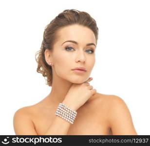 beautiful woman wearing pearl earrings and bracelet
