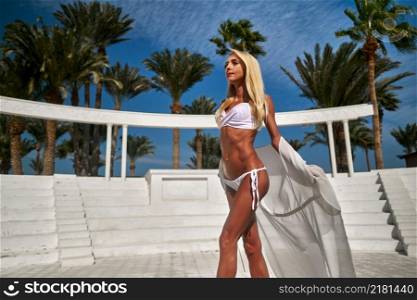 Beautiful woman wearing swimsuit and pareo standing against the background of the amphitheater.. Beautiful woman wearing swimsuit and pareo standing against the background of the amphitheater