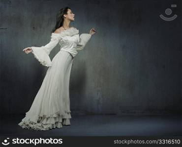 Beautiful woman wearing white dress over a grungy wall