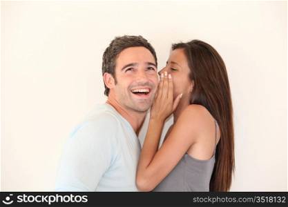 Beautiful woman whispering to boyfriend&acute;s ear
