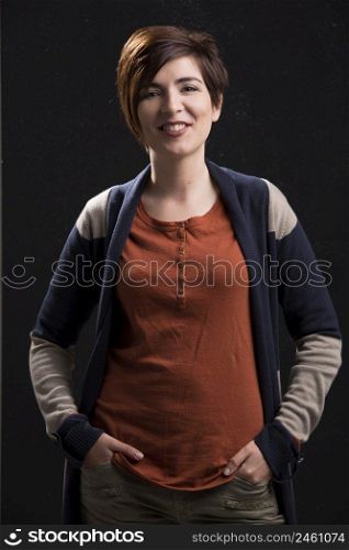Beautiful woman with a modern hair cut, standing over a dark background