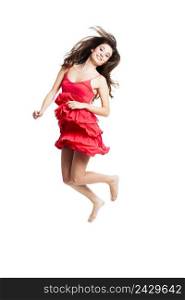 Beautiful woman with a red dress dancing and jumping, isolated on white