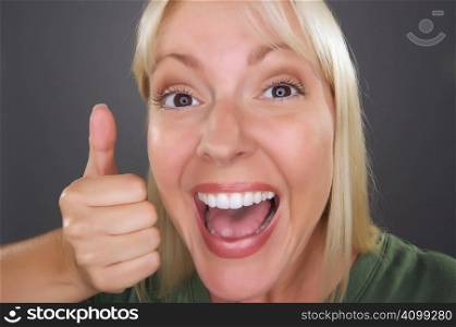 Beautiful Woman with a Thumbs Up Against a Grey Background.