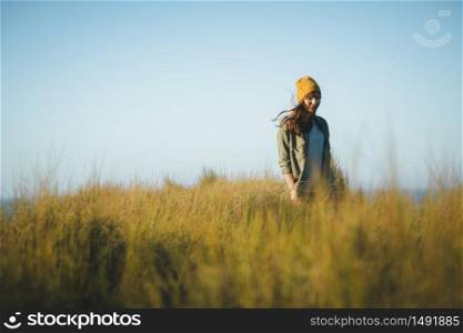Beautiful woman with a yellow cap and walking alone