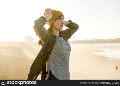 Beautiful woman with a yellow cap looking to the beach enjoying the view 