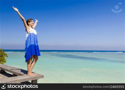 Beautiful woman with arms open enjoying the summer